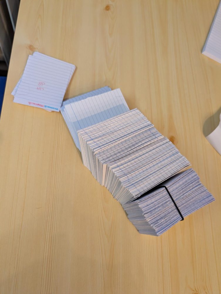 A large deck of flashcards fanned out on a desk
